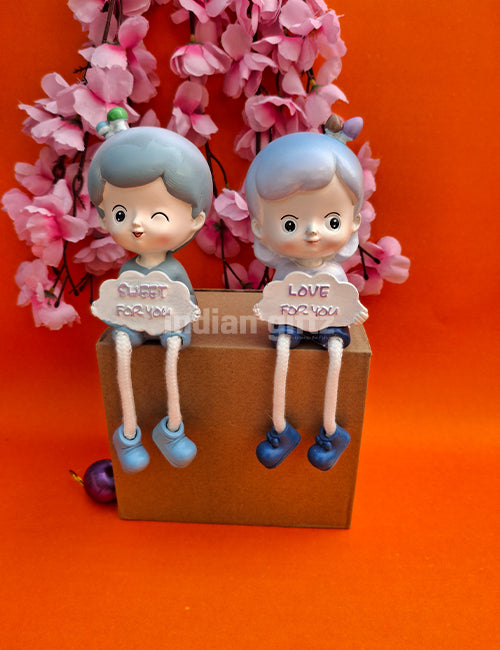 Cute Boy & Girl Love Sharing Hanging Legs Dolls – Polyresin Decorative Showpiece suitable for Tabletop Decoration Gifting, Home Decor, Table, Office Table
