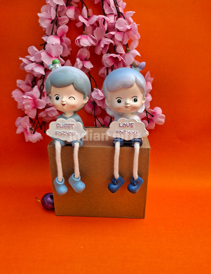 Cute Boy & Girl Love Sharing Hanging Legs Dolls – Polyresin Decorative Showpiece suitable for Tabletop Decoration Gifting, Home Decor, Table, Office Table